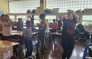  5th grade class being taught a traditional Hispanic dance